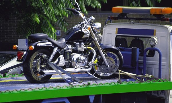 Moto sanglée sur le plateau d’une dépanneuse